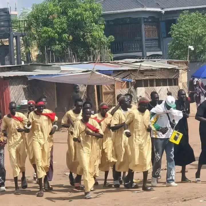 Cueibet fans running at Munuki Playground while carrying sticks